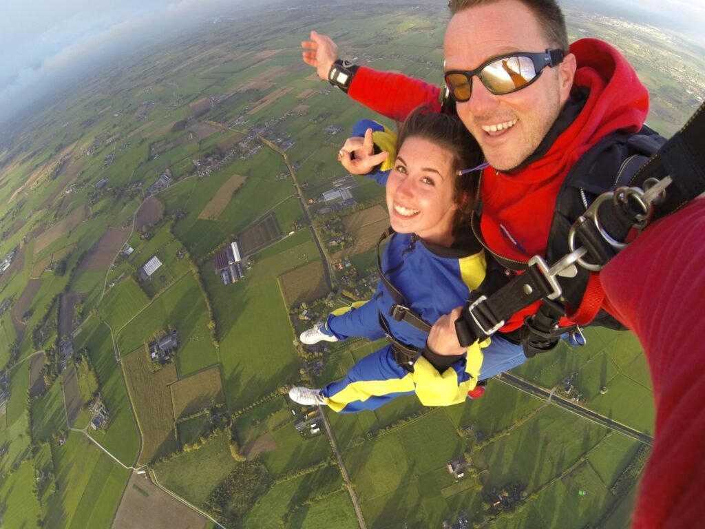 Mastering the First Impression: Your intriguing post title goes here A thrilling tandem skydive experience captured with a panoramic view of lush farmland below.